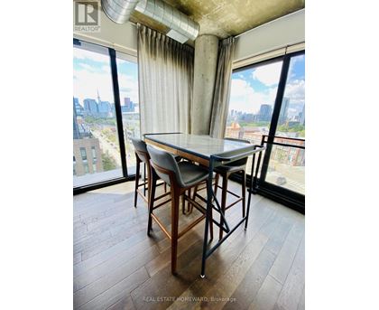 A dining room with a table and chairs and a view of the city.