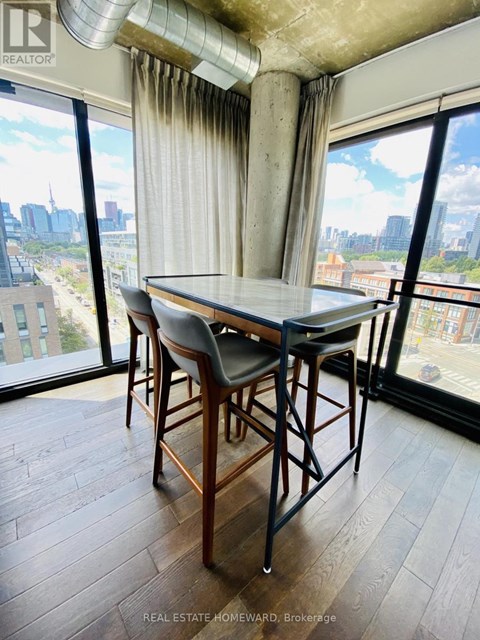 A dining room with a table and chairs and a view of the city.