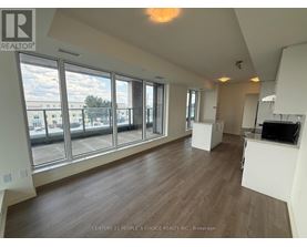 A spacious room with wooden floors and large windows overlooking a cityscape.