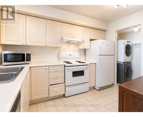 A kitchen with white appliances and wooden cabinets.