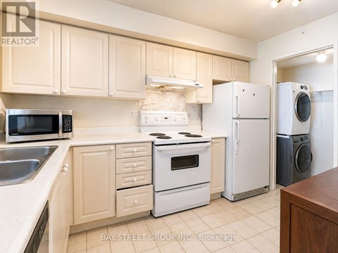 A kitchen with white appliances and wooden cabinets.
