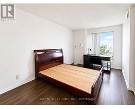 A bedroom with a bed, desk, and chair.