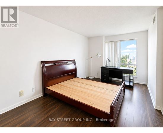 A bedroom with a bed, desk, and chair.