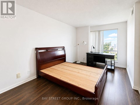 A bedroom with a bed, desk, and chair.