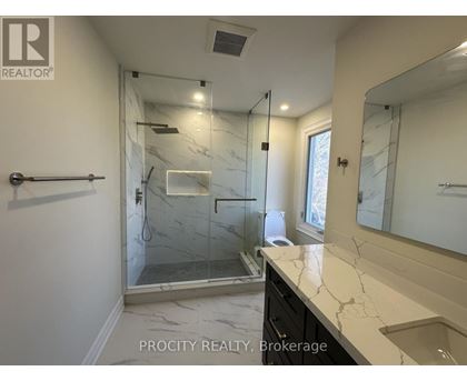 A bathroom with a marble countertop and a walk-in shower.