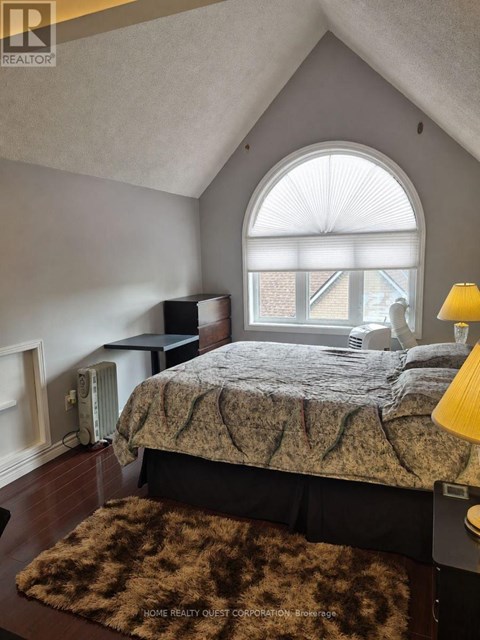 A bedroom with a bed, a window, and a rug.