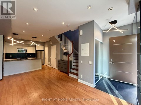 A spacious home interior with wood flooring and a staircase.