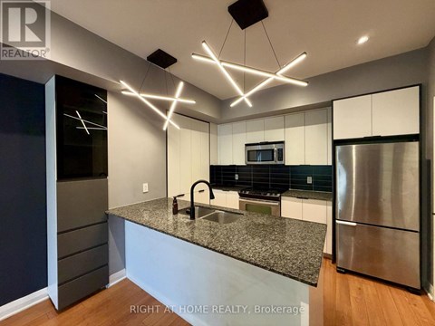 A modern kitchen with granite countertops and stainless steel appliances.