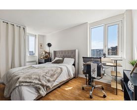 A bedroom with a bed, desk, and chair.