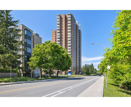 A street view with a tall building on the right.