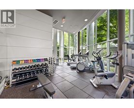 A gym with a variety of equipment including weights, a bench, and a treadmill.