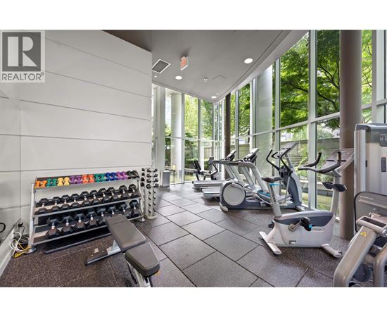 A gym with a variety of equipment including weights, a bench, and a treadmill.