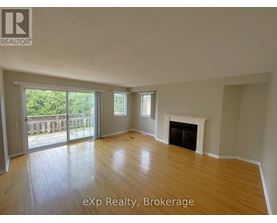 A spacious room with a fireplace and sliding glass doors leading to a deck.