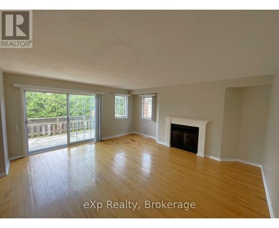 A spacious room with a fireplace and sliding glass doors leading to a deck.