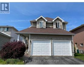 A house with a brown roof and two white garage doors.