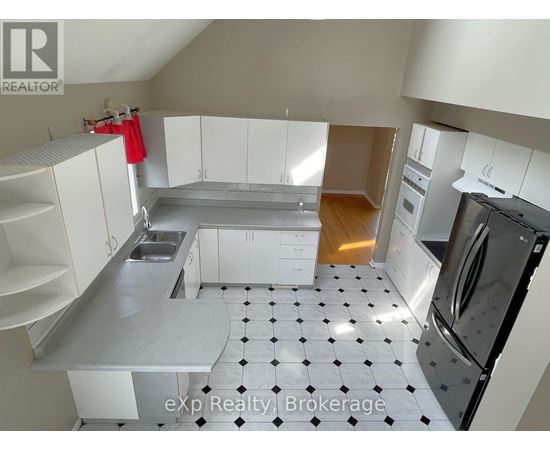 A kitchen with white cabinets and a black and white checkered floor.