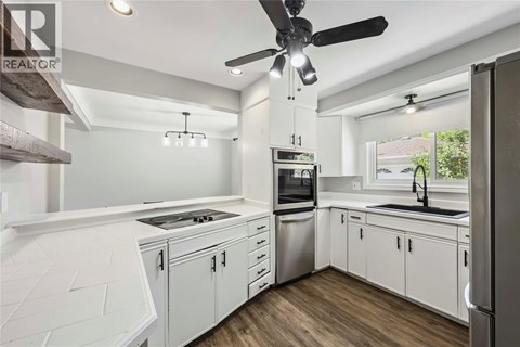 A modern kitchen with white cabinets and stainless steel appliances.