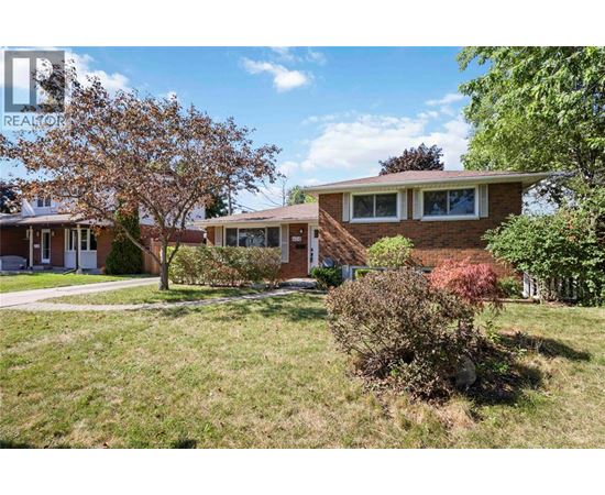 A house with a lawn and trees in front of it.