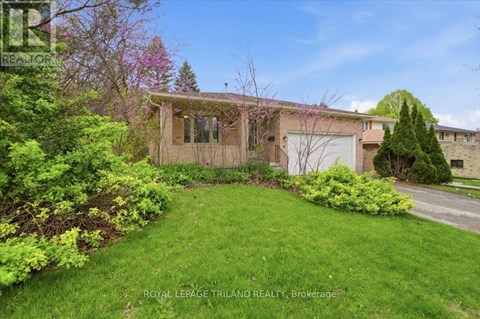 A house with a green lawn and trees in the background.