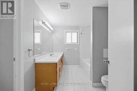A bathroom with a sink, mirror, and bathtub.