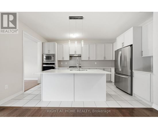 A white kitchen with a refrigerator on the right.