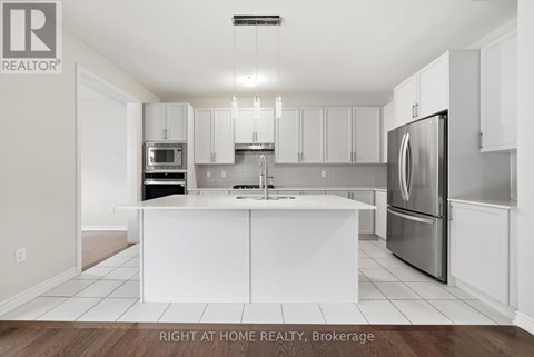 A white kitchen with a refrigerator on the right.
