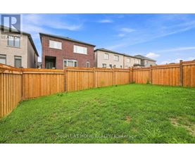 A backyard with a wooden fence and grass.