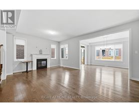 A spacious living room with wood flooring and a fireplace.