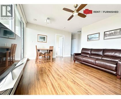 A living room with a brown leather couch and wooden floors.