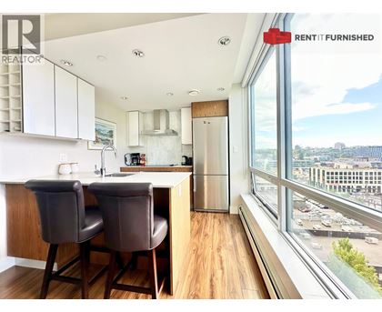 A kitchen with brown chairs and a view of the city.