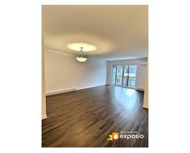A room with wooden floors and a window with bars on it.