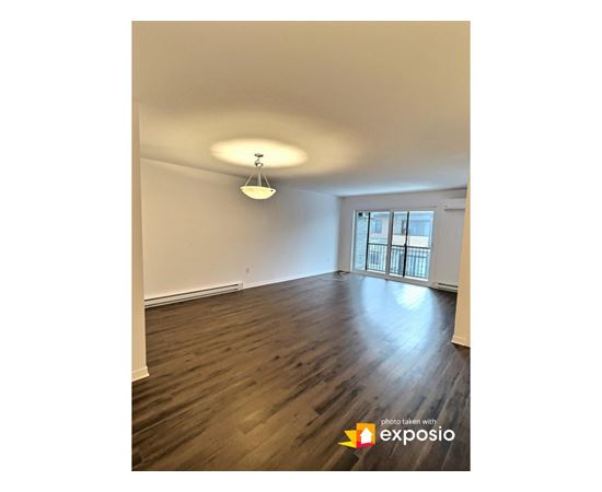 A room with wooden floors and a window with bars on it.