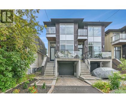 A modern two-story house with a large front yard and a balcony on the second floor.