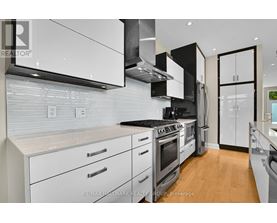 A modern kitchen with white cabinets and stainless steel appliances.