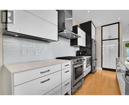 A modern kitchen with white cabinets and stainless steel appliances.