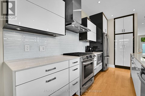 A modern kitchen with white cabinets and stainless steel appliances.