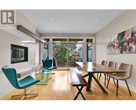 A modern dining room with a long table and chairs.