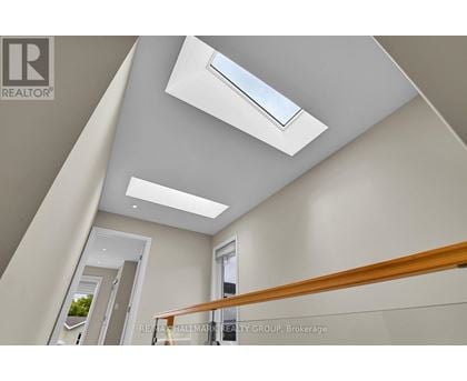 A modern interior space with a skylight and a wooden railing.