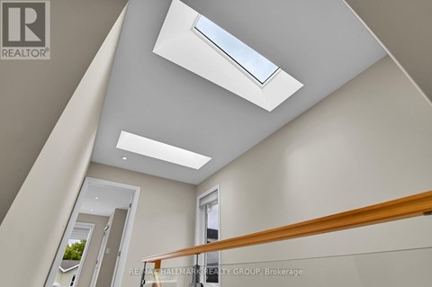 A modern interior space with a skylight and a wooden railing.