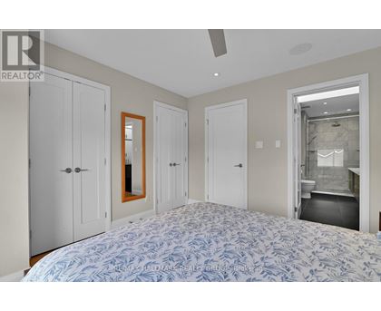 A bedroom with a large bed and a mirror on the wall.