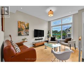 A living room with a brown leather couch and a glass coffee table.