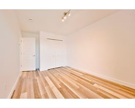 A room with wooden flooring and white walls.
