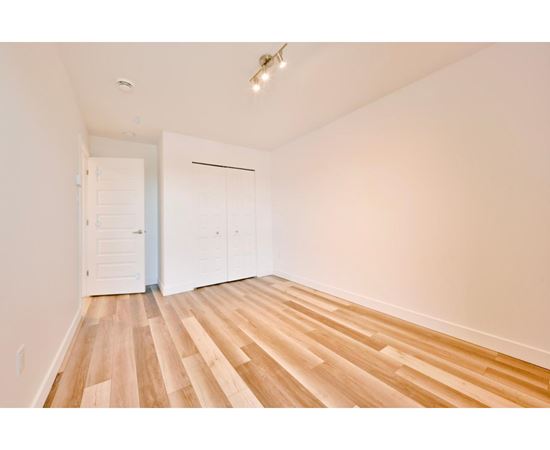 A room with wooden flooring and white walls.