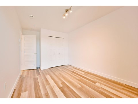 A room with wooden flooring and white walls.