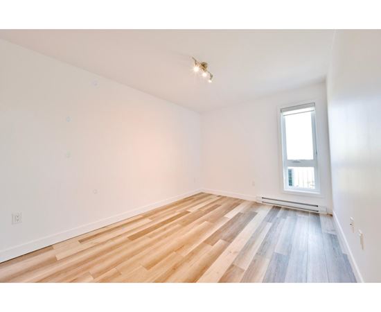 A room with wooden flooring and a window.