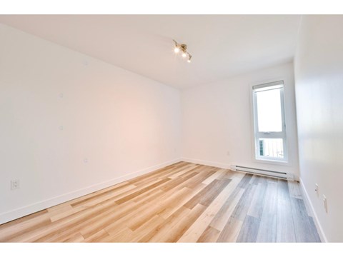 A room with wooden flooring and a window.