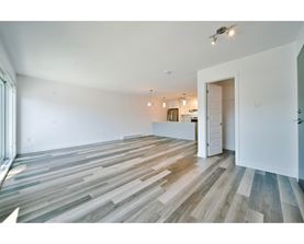 A room with wooden flooring and white walls.