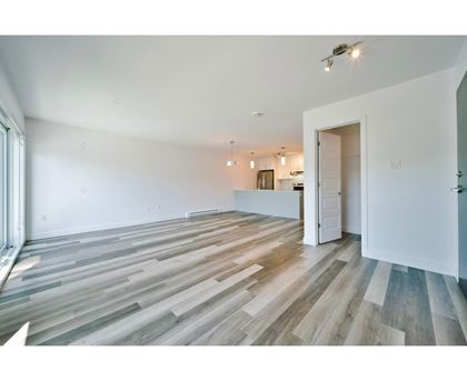 A room with wooden flooring and white walls.