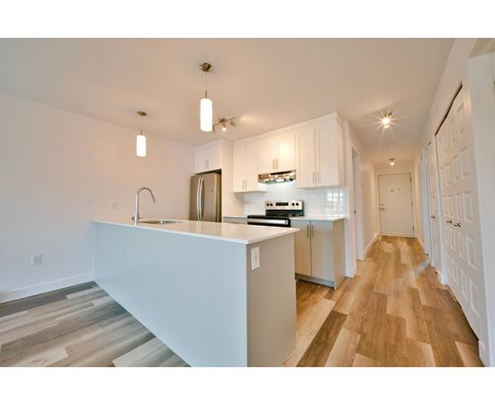 A kitchen with white cabinets and a white island.