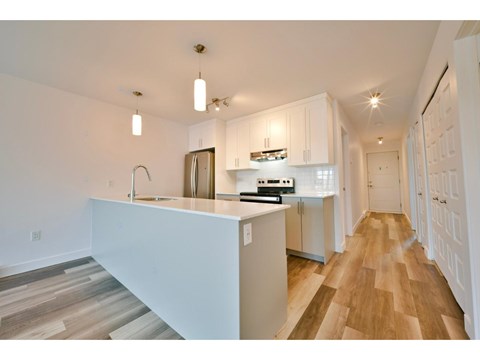 A kitchen with white cabinets and a white island.